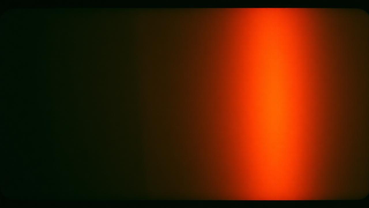 Warm orange light leak across a dark 35mm film frame with heavy grain texture, analog photo aesthetic